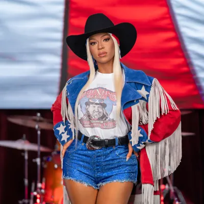 Madame Tussauds Orlando’s wax figure of Beyoncé posing in front of glowing 'COWBOY' letters.