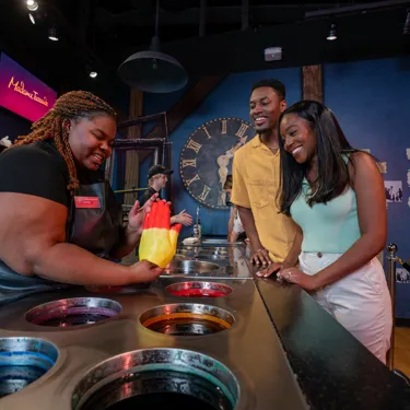 Couple smiles after their wax hands were dipped in red and yellow at Madame Tussauds Orlando.
